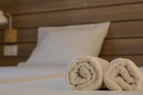 two rolled up towels sitting on a bed at Ilaeira rooms in Argasi