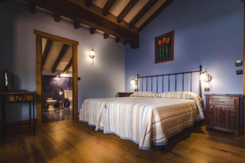 a bedroom with a large bed and a bathroom at Posada La Aldea in Oreña