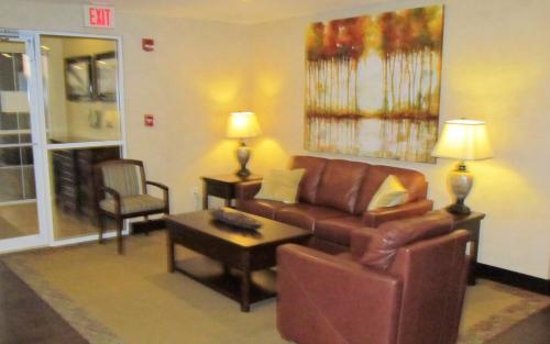 a living room with a brown couch and a table at Oak Hill Inn & Suites in Canton