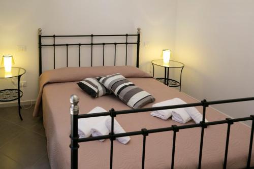 a bedroom with a bed with two pillows on it at Boa Vista San Vito - Area Fitness, Barbecue Area, Tennis Court in San Vito lo Capo
