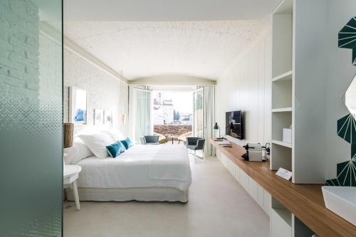 a white bedroom with a bed and a television at Boutique Hotel Villa Gala by Fimedhotels in Cadaqués