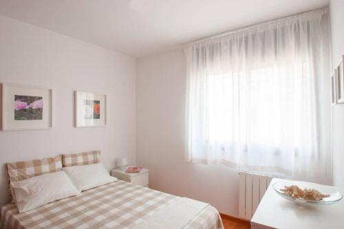 シッチェスにあるCapricho Apartamento Sitgesの白いベッドルーム(ベッド1台、窓付)