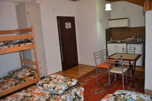 Habitación pequeña con mesa, sillas y cocina. en Hostel Valentin en Ohrid