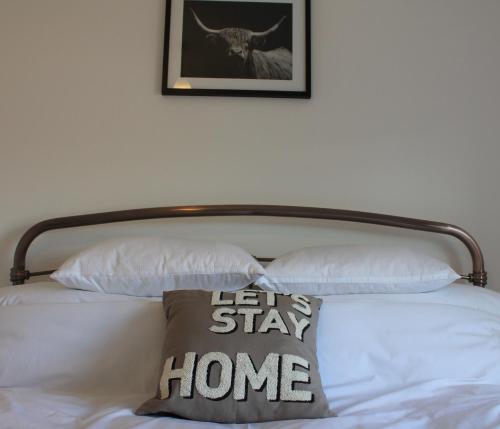 a bed with a wooden headboard and a pillow on it at No.10 in Stornoway