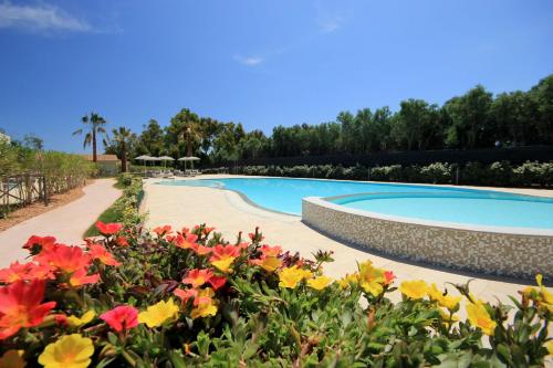 a swimming pool in a garden with flowers at Ville D'Ogliastra in Cardedu