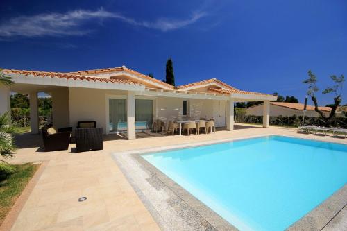 a swimming pool in front of a house at Ville D'Ogliastra in Cardedu
