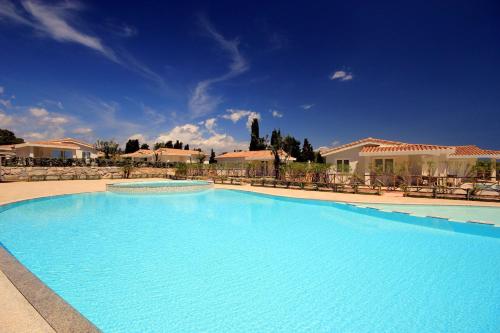 a large blue swimming pool in a resort at Ville D'Ogliastra in Cardedu