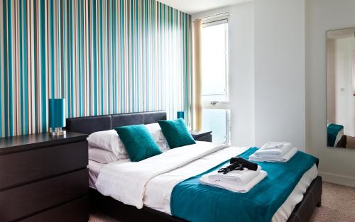 a hotel room with a bed with towels on it at Apartment in Central MK - Bed Choice of 1 Super-king Or 2 Singles and also 2 Sofa Beds - Free Parking and Smart TV - Contractors, Relocation, Business Travellers in Milton Keynes
