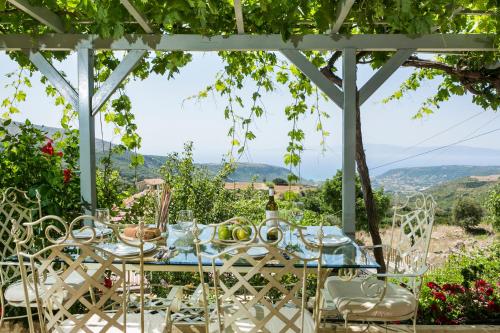 a table under a pergola with a table and chairs at Sandy & Sofia in Katelios