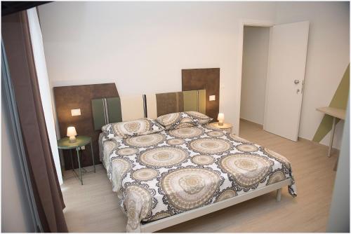 a bedroom with a large bed with a patterned blanket at Dolce Vita in Zafferana Etnea