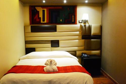 a room with a bed with a stuffed animal on it at Hotel Royal Qosqo in Cusco