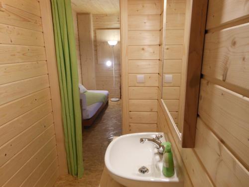 a bathroom with a sink and a bed in a room at L'Atelier de Gisèle in Oberhaslach