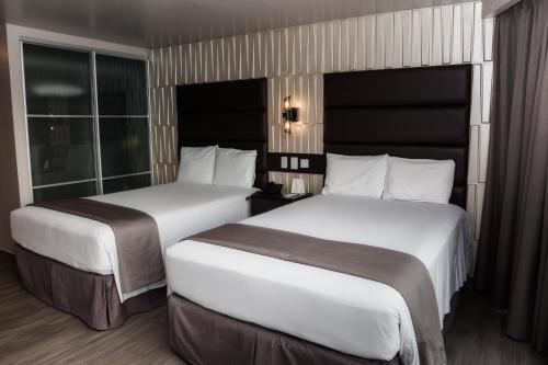 two beds in a hotel room with two beds at Plaza Paitilla Inn in Panama City