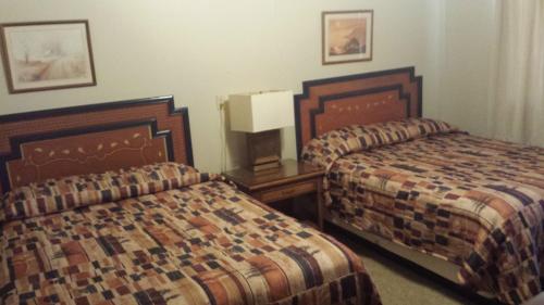 a hotel room with two beds and a night stand at Badlands Hotel & Campground in Interior