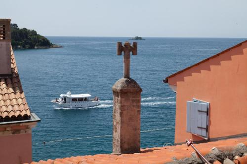 a cross on top of a building with a boat in the water at Apartments and Rooms Hey Rovinj in Rovinj