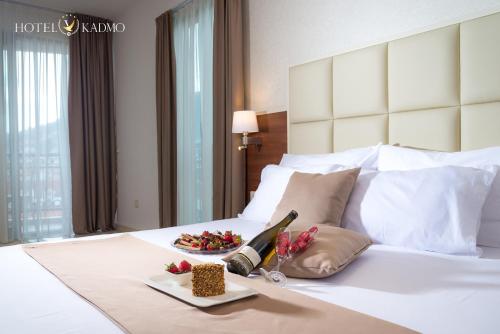 a hotel room with a white bed with a plate of food at Hotel Kadmo by Aycon in Budva