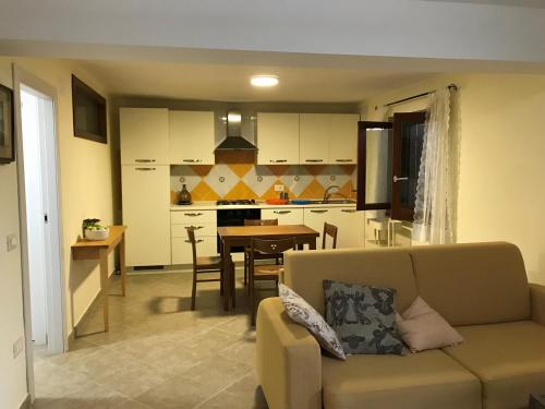 a living room and kitchen with a couch and a table at La casa del Maestro in Pisciotta