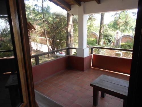 a porch with a wooden bench and a table at Cabañas los Venados in Mazamitla