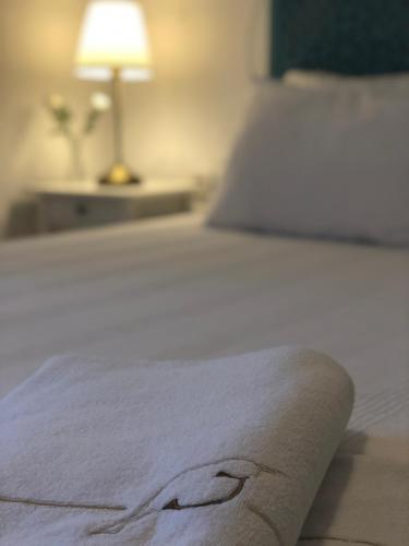 a bed with a white blanket on top of it at Jakamar Alacati in Alacati
