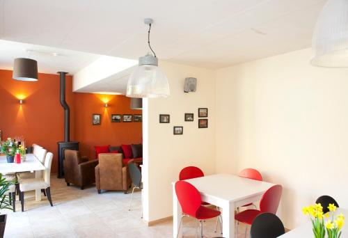 a dining room with red chairs and a white table at Leuven City Hostel in Leuven