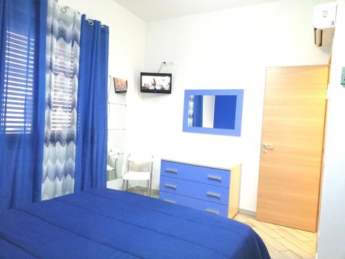 a bedroom with a blue bed and a mirror at Capo d'Orlando Apartments in Capo dʼOrlando