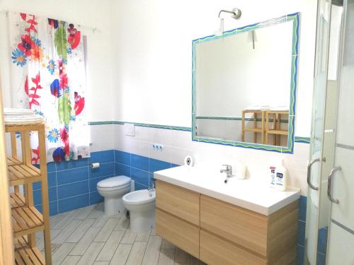 a bathroom with a sink and a toilet and a mirror at Capo d'Orlando Apartments in Capo dʼOrlando