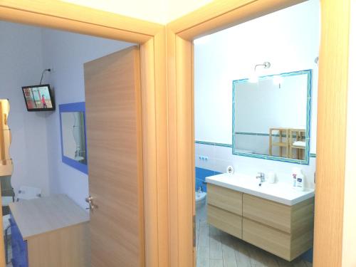a bathroom with a sink and a mirror at Capo d'Orlando Apartments in Capo dʼOrlando