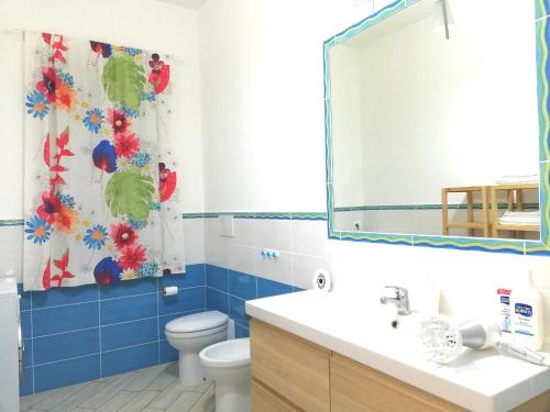 a bathroom with a toilet and a sink and a mirror at Capo d'Orlando Apartments in Capo dʼOrlando