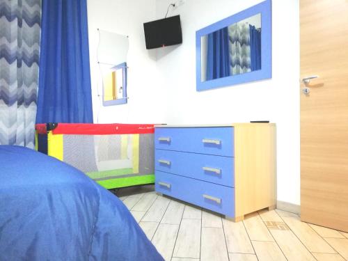 a bedroom with a blue dresser and a tv at Capo d'Orlando Apartments in Capo dʼOrlando