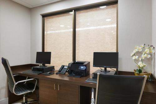 an office with a desk with two computer monitors on it at Matiz Multi Suites in Duque de Caxias