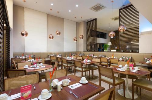 a dining room with wooden tables and chairs at Matiz Multi Suites in Duque de Caxias