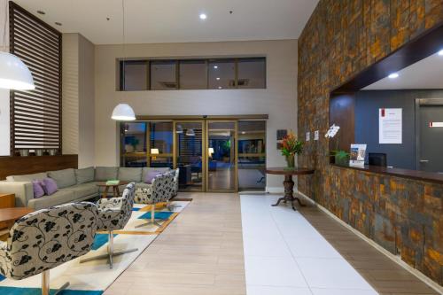 a living room filled with furniture and a large window at Matiz Multi Suites in Duque de Caxias