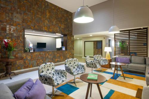 a living room with a couch and chairs at Matiz Multi Suites in Duque de Caxias