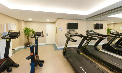a gym with treadmills and ellipticals in a room at Matiz Multi Suites in Duque de Caxias