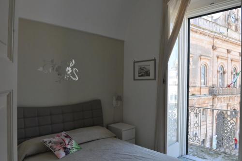 a bedroom with a bed and a large window at Archivio dei Ricordi - Casa con vista a Ostuni in Ostuni