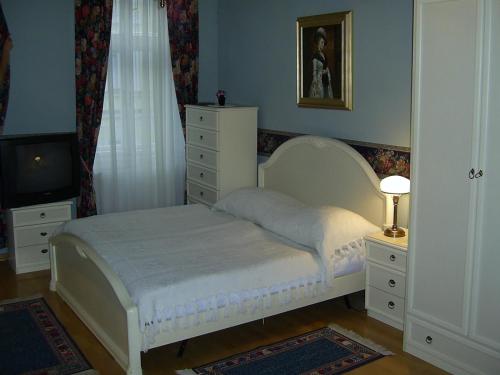 a bedroom with a bed and a dresser and a television at Pension Šejko in Horní Planá