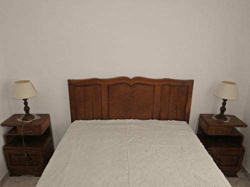 a bedroom with a wooden bed with two night stands at Casa Eira do Povo 1 in Vale de Colmeias