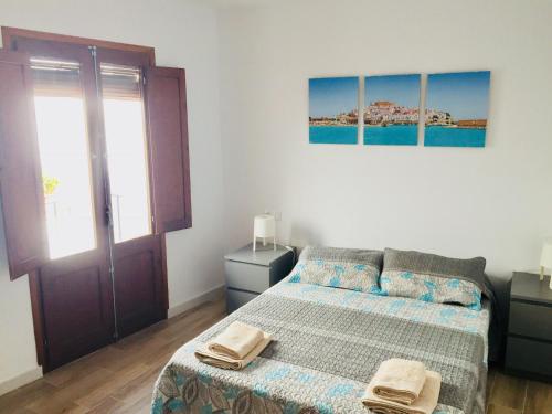 a bedroom with a bed with two towels on it at Casa casco antiguo, junto al Bufador in Peniscola