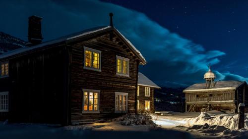 a log cabin in the snow at night at Kvaale Gard in Lom