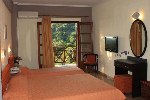 a bedroom with two beds and a window with a view at Athorama Hotel in Ouranoupoli
