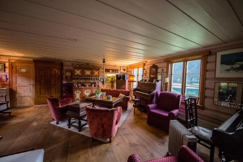 a living room filled with furniture and a piano at Kvaale Gard in Lom