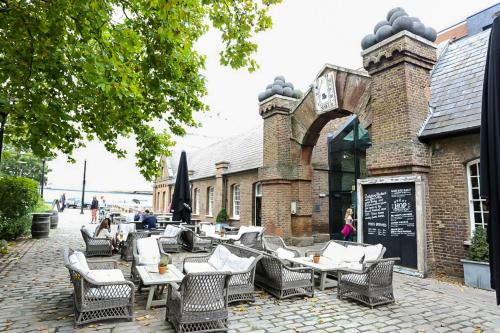 a group of chairs and tables in front of a building at Superior 2 bedroom Apartments in Woolwich
