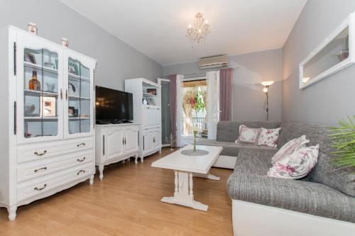 ein Wohnzimmer mit einem Sofa und einem TV in der Unterkunft Comfort apartment with garage Aria in Vrgorac