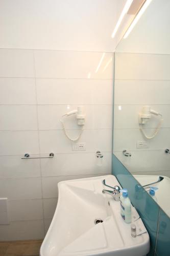 a bathroom with a white sink and a mirror at Ville D'Ogliastra in Cardedu