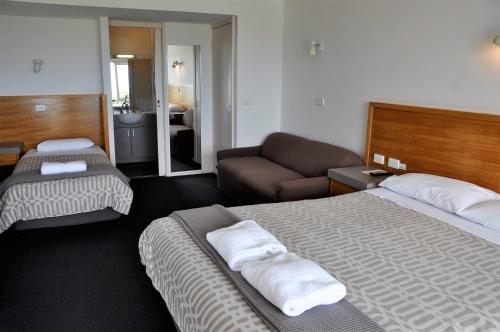 een hotelkamer met 2 bedden en een bank bij A Great Ocean View Motel in Apollo Bay