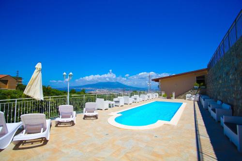 a patio with chairs and a swimming pool on a building at B&B Villa Catiè in Castellammare di Stabia