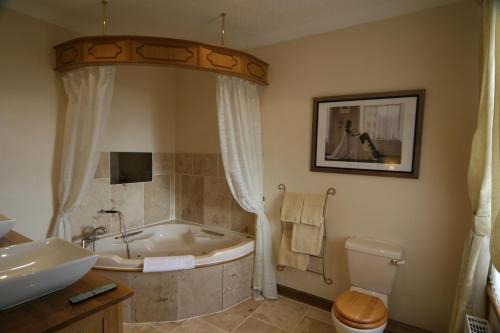 a bathroom with a tub and a toilet and a sink at Anvil View Guest House in Gretna Green