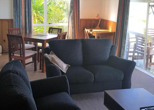 a living room with a blue couch and a table at Seaview Norfolk Island in Burnt Pine