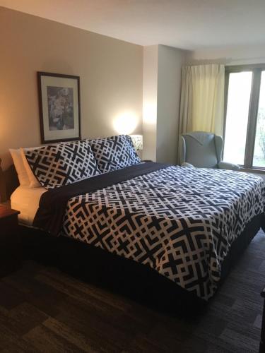 a bedroom with a bed with a black and white comforter at Lull-Abi Inn in Egg Harbor