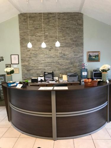 a lobby with a reception desk with a brick wall at White Birches Motel in Ellsworth